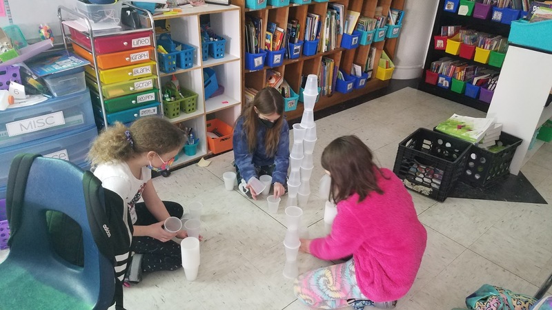 Students building cup towers